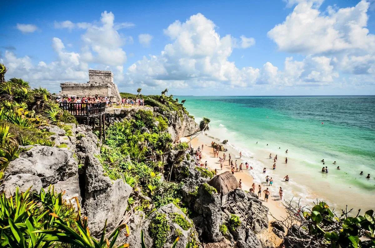 things to do in Tulum like visit the archaeological site which sits on this rock and looks out over a beach on the Caribbean Sea.