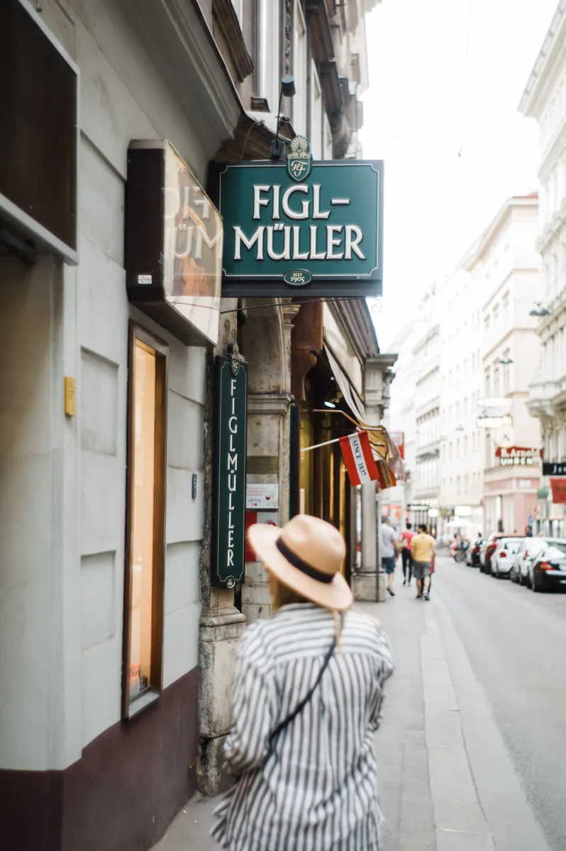 figmüller restaurant in vienna with woman walking under the sign