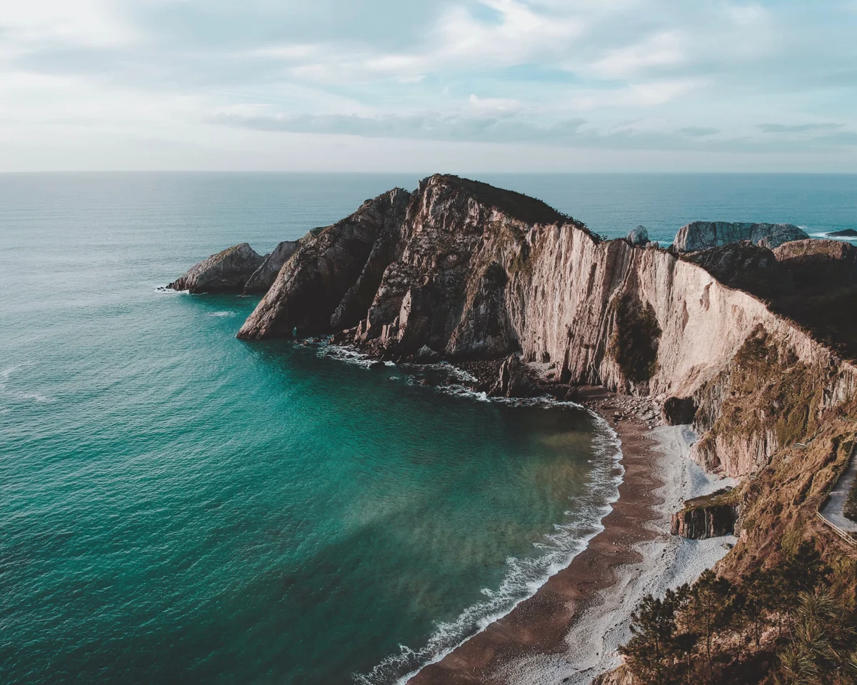 playa del silencio in spain with tall cliffs and a beautiful sandy beach.
