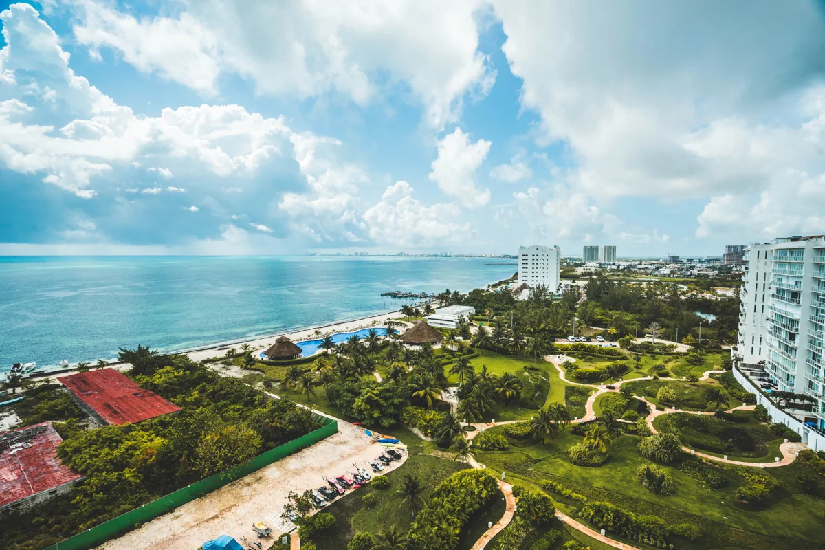 lush green space over in front of turquoise waters after the rainy season in cancun which is the best time to visit cancun.