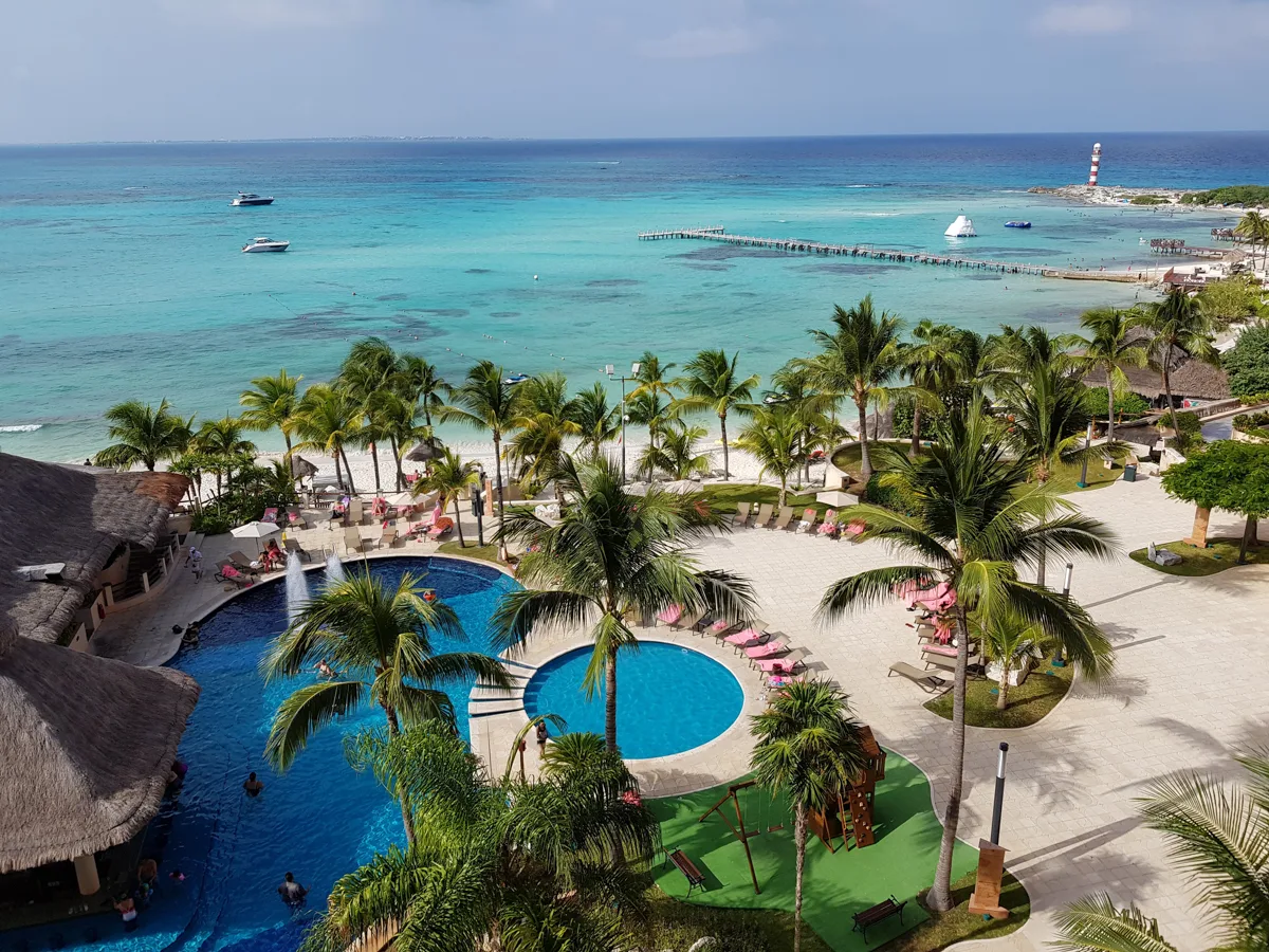 swimming pool with the Caribbean sea in the background over a resort in Cancun.