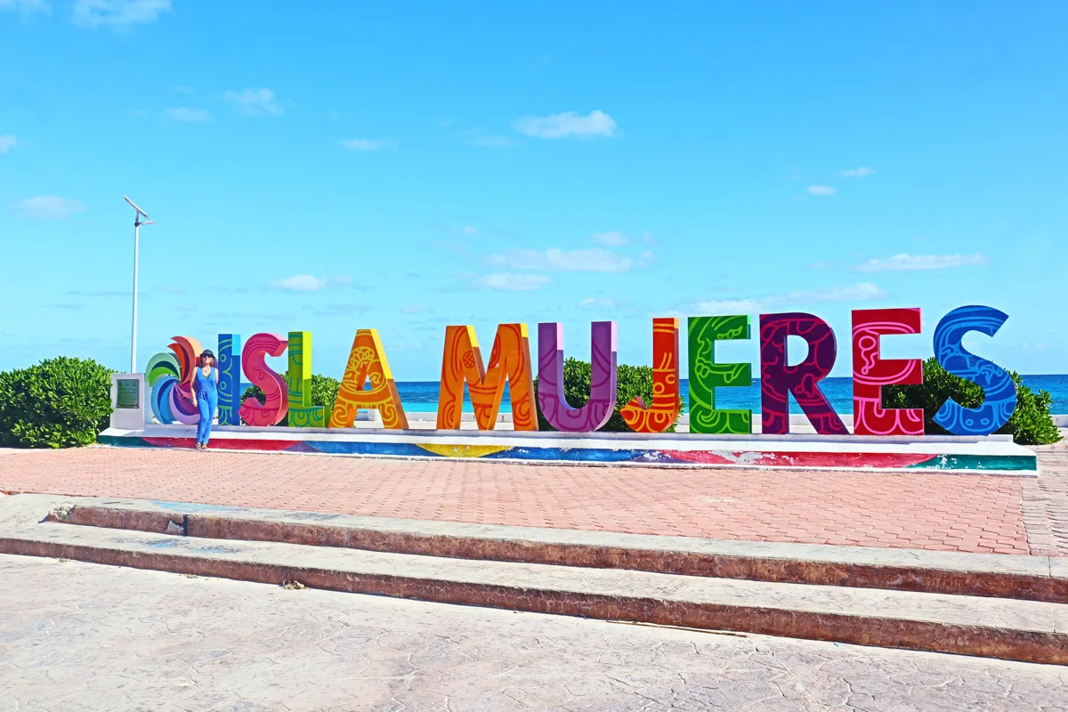 colorful sign that says isla mujeres with blue skies.