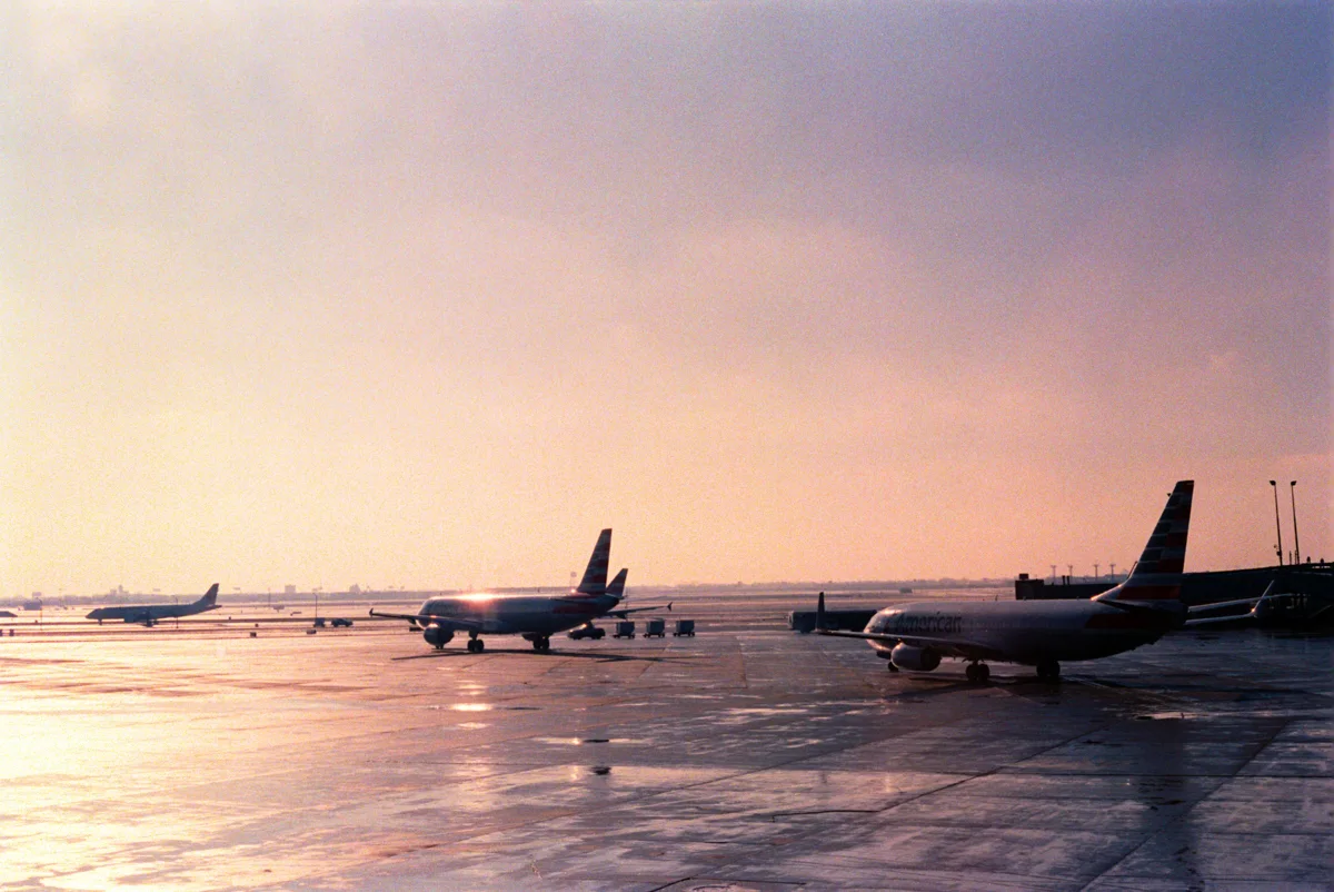 pink and purple sky with airplanes on the tarmac at santiago airport.