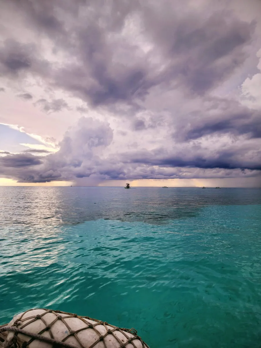 turquoise water with dark clouds above.