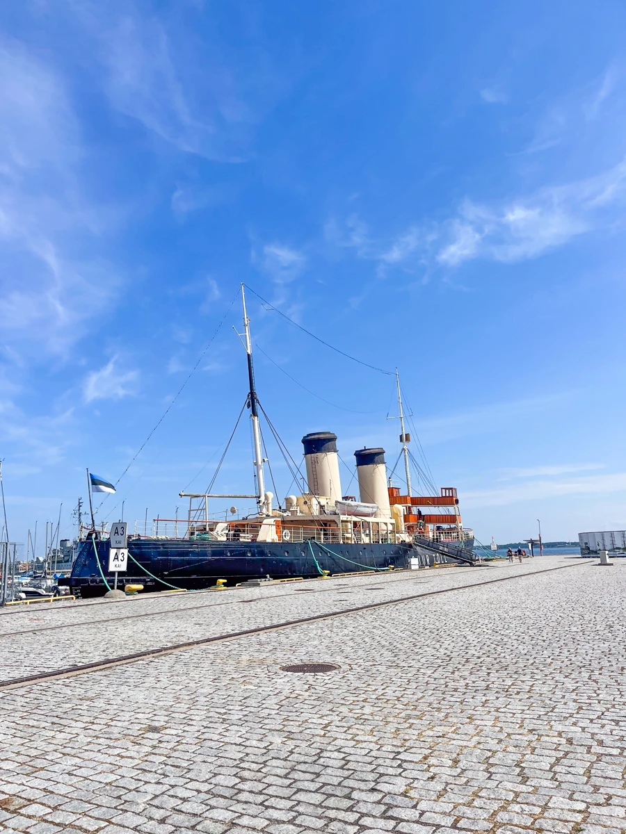 ship at a small harbour with steam pipes coming out of the top.