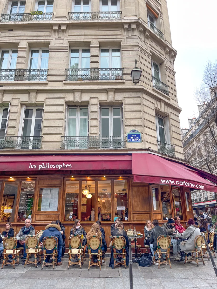 city scape in paris with cafe and people sitting outside.