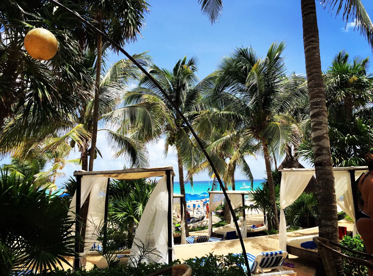 blue skies with a beach club full of beach beds out on the sand make it the best time of year to visit playa del carmen.