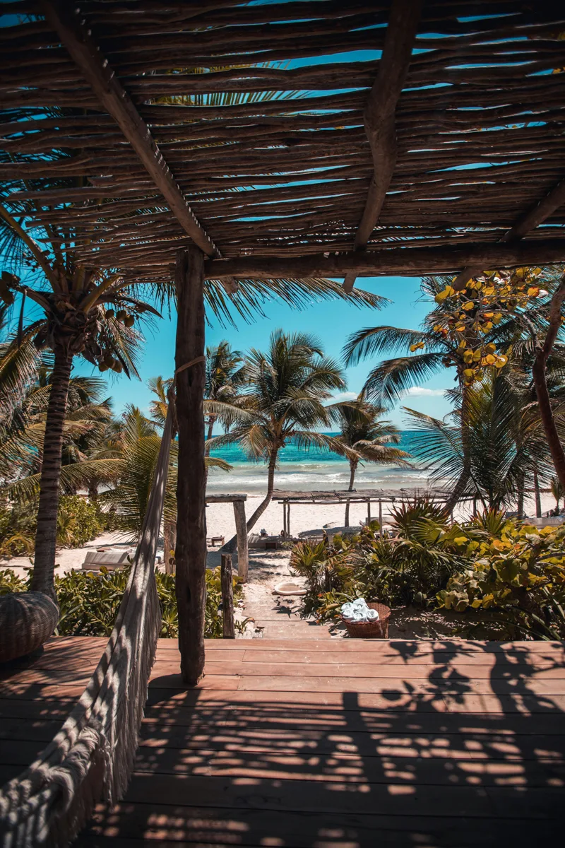 beach club with wooden shack on the beach and the sea in the distance.