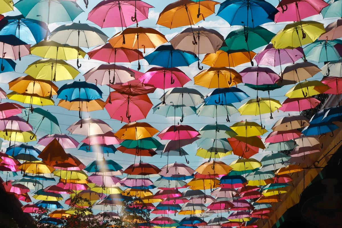 colorful umbrellas hung over a street.