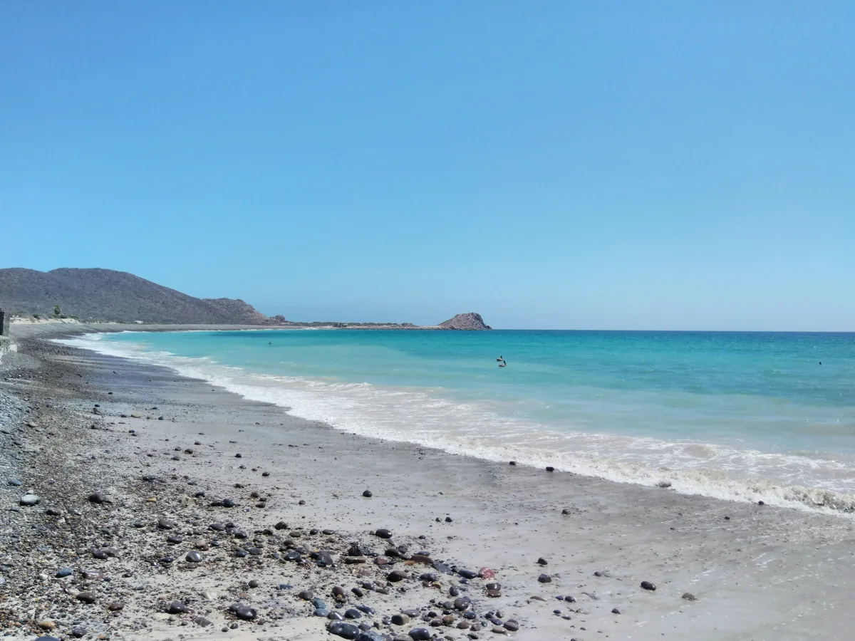 long stretch of grey sand with turquoise waters.
