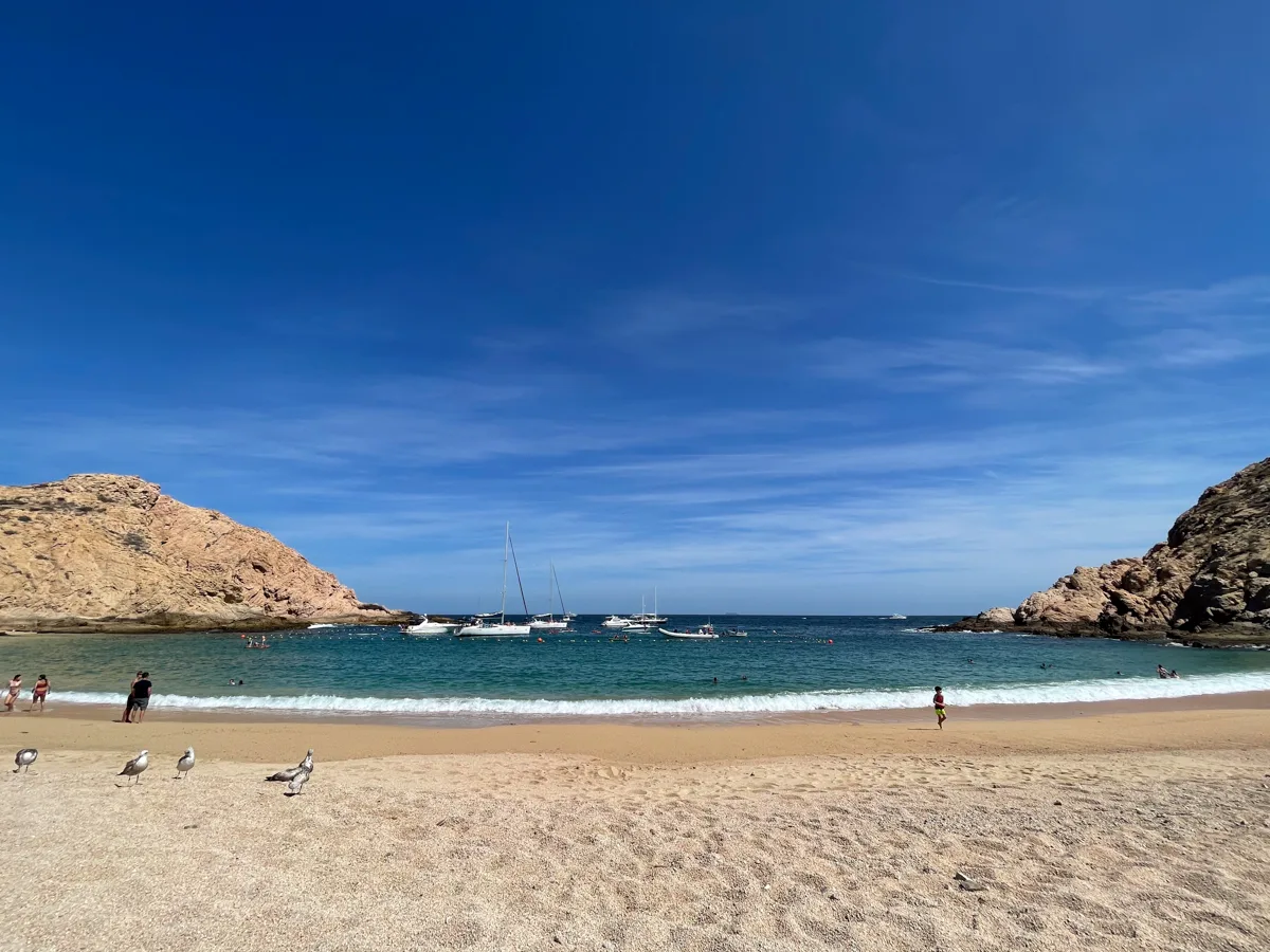 santa maria beach with two rock formations on either side of the bay and water in the middle with sand at the forefront and water at the back.