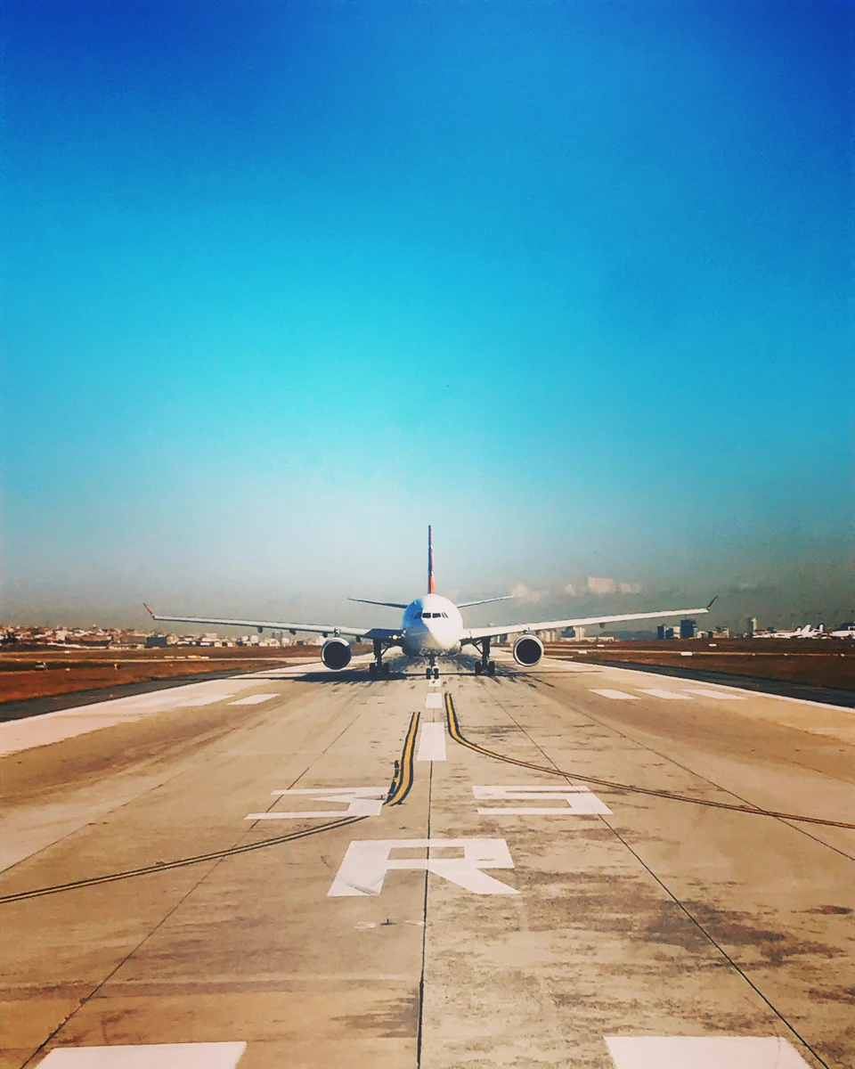 plane on a runway with bright blue skies.