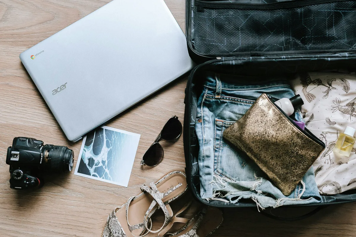 bag open with a laptop and a camera on the side of the bag which can all be covered with travel medical insurance.