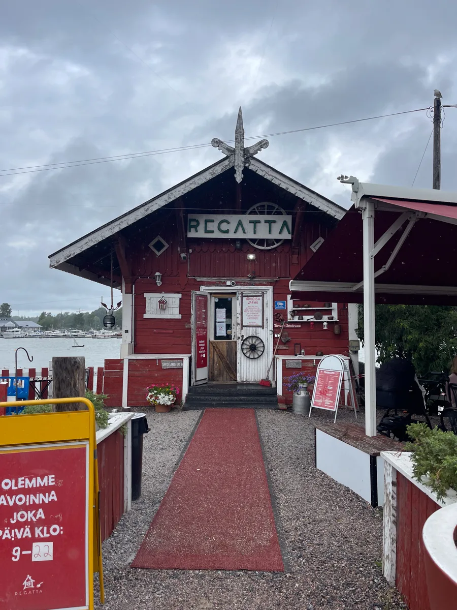front of a red wooden building with a red walkway to the front entrance and a white sign at the top of the building that says Regatta.