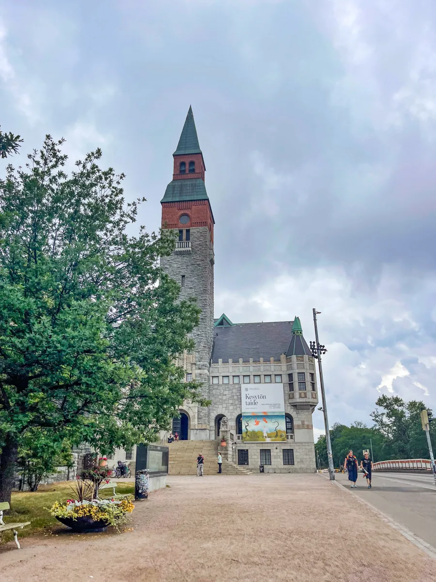 tall castle-like building with a bell tower and a lower turret building to the right of it.