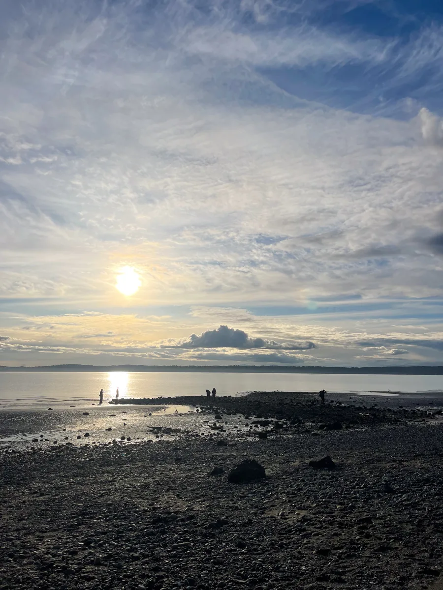 sunset over the beach with mountains in the distance.