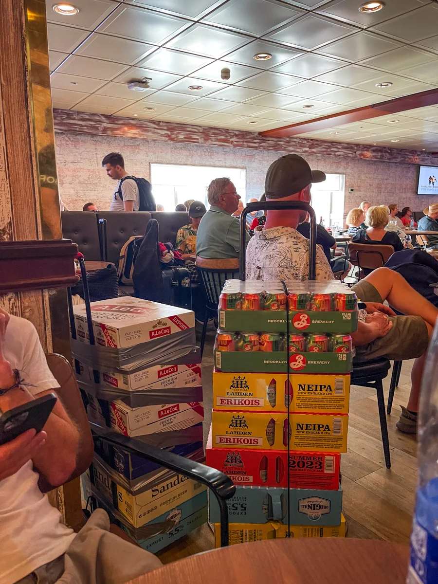 cases of beer stacked on top of each other in a pile on a hand cart.