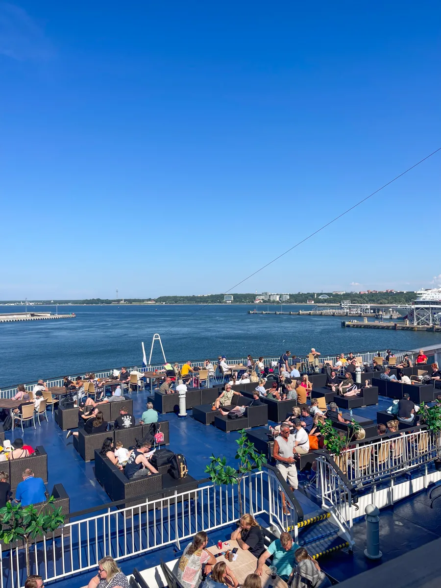 the front of the ferry from tallinn to Helsinki with lots of people sitting on picnic tables and lounge chairs.