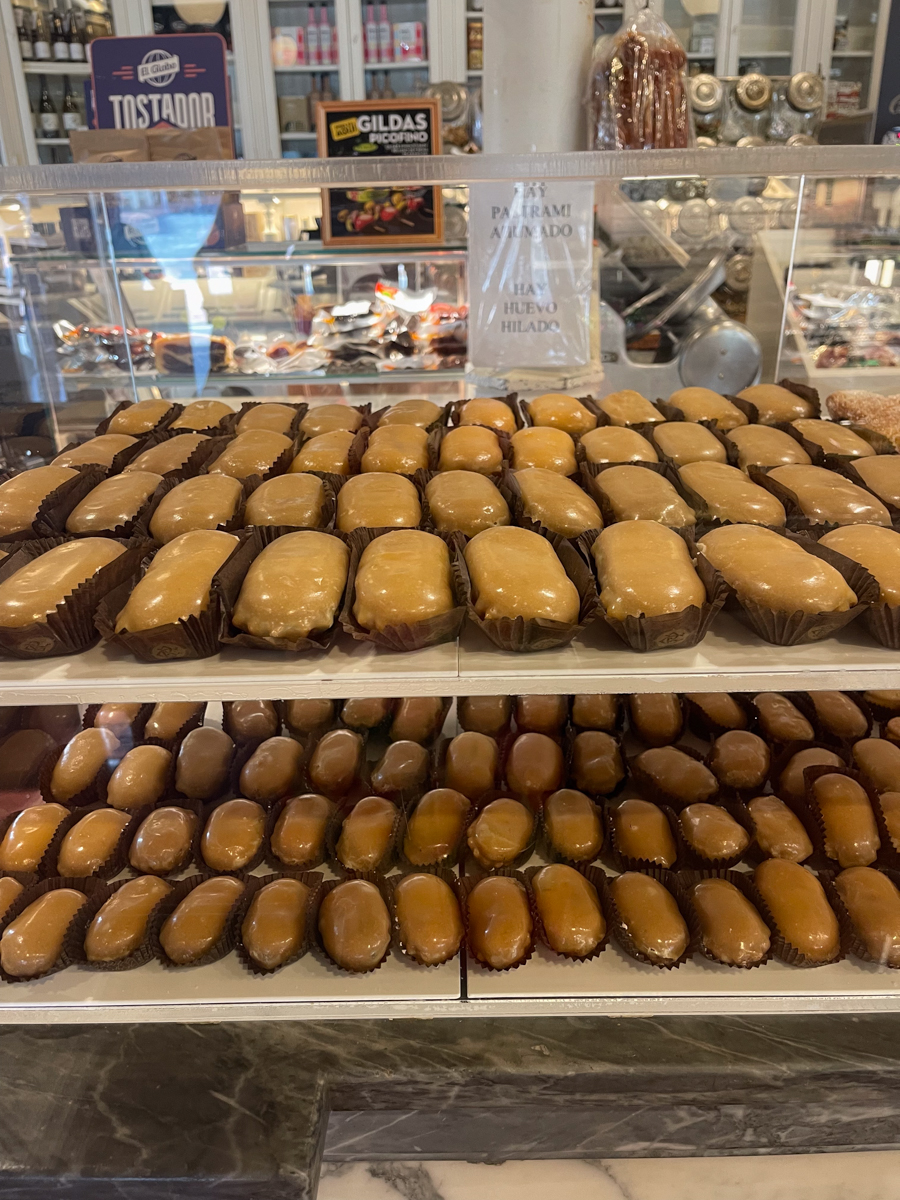rows of carbayón pastry in asturias, glazed along the top and sitting in a small brown paper.