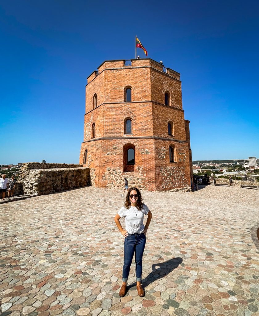 woman standing in front of gedeminas tower in Vilnius, lithuania 